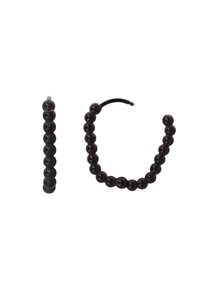 Sorte perleaccessories: ett langstrakt sylinderstykke og en sirkulær ring med en serie like runde perler, med jevn tekstur.