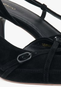Czarne zamszowe buty na wysokim obcasie z krzyżującymi się paskami i metalowymi akcentami. Gładka podszewka i stożkowy kształt noska.
