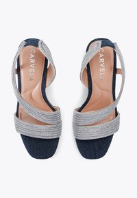 Sandali in denim blu navy con punta quadrata, cinturini intrecciati in tono argento e suola liscia con il marchio "CARYELA".