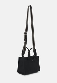 Black fabric tote bag with dual top handles and adjustable striped shoulder strap. Features a structured shape and front seam detailing.