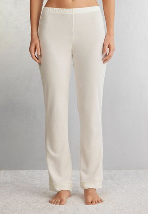 Witte geribde pyjamabroek met een brede elastische tailleband, rechte pijpen en strakke boorden bij de enkels, weergegeven op een lichte achtergrond.