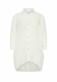 Camisa blanca de botones con mangas largas, con lunares texturizados, dobladillo curvo y botones en tono dorado. Tejido ligero y cuello con solapa.