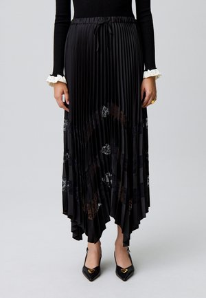 Jupe midi plissée noire avec une taille à cordon et des accents en dentelle florale, présentant une finition texturée et un ourlet asymétrique.