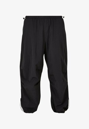 Čierne ľahké pracovné nohavice majú elastický pás, šnúrku na stiahnutie, voľný strih a manžety na členkoch. Hladká štruktúra bez viditeľných vzorov.