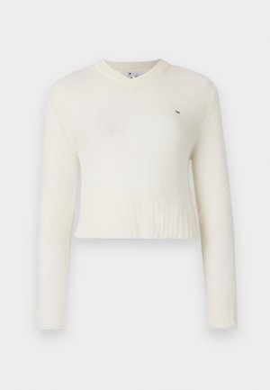 Hvit, cropped genser med lange ermer og V-hals. Laget av mykt materiale med ribbestruktur nederst. Lite logo på brystet.