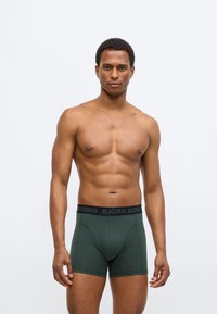 Πράσινα ανδρικά σλιπ boxer με μαύρη μέση που φέρει το λογότυπο "BJÖRN BORG". Απαλή βαμβακερή σύνθεση, εφαρμοστό σχέδιο με λείο υφή.