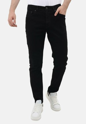 Zwarte denim jeans met een slim fit, met een knoopsluiting, voorzakken en een zachte textuur, gecombineerd met witte sneakers.