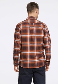 Camicia a quadri marroni con accenti arancioni, bianchi e blu; presenta un colletto button-down e maniche lunghe con polsini a bottone.