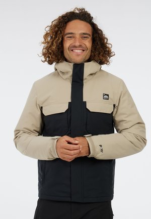 Men's color-blocked jacket in beige and navy, features a high collar, two chest pockets, and elastic cuffs, designed for outdoor use.