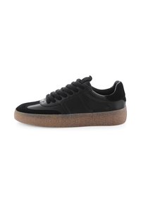 Schwarze Low-Top-Sneaker mit dicker, durchsichtiger, brauner Gummisohle und strukturiertem Obermaterial aus Wildleder und Leder.