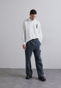 Études PANT EMBROIDERED - Tracksuit bottoms - navy