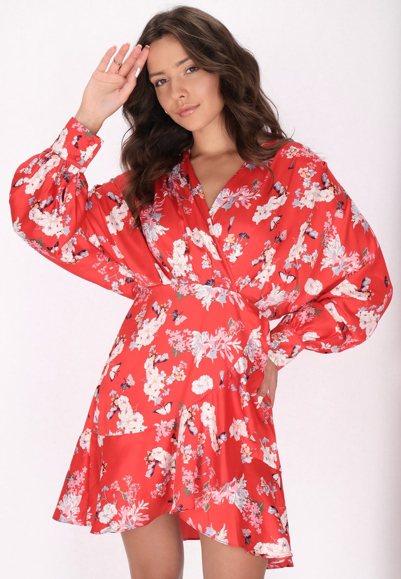 Rotes Blumenkleid mit langen, puffigen Ärmeln und V-Ausschnitt. Hergestellt aus glattem Stoff und mit weißen und blauen Blumenmustern verziert. Dunklere Akzente vorhanden.