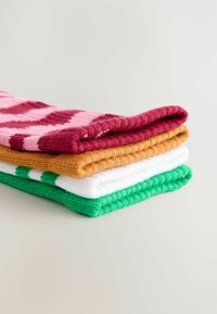 Fire par sokker stablet: lyserøde med en zigzag-mønster, orange, hvide og grønne med vandrette striber; alle har ribbet tekstur og blødt materiale.