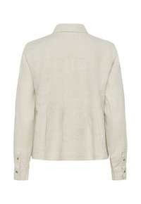 Veste longue en lin beige à manches longues, avec plis au dos, poignets boutonnés et col classique, vue de dos.