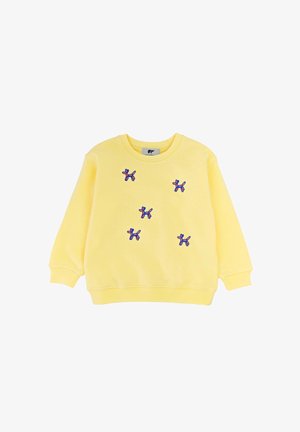 Felpa gialla a maniche lunghe con cinque piccoli disegni ricamati di cani a palloncino blu e rossi sparsi sul davanti.