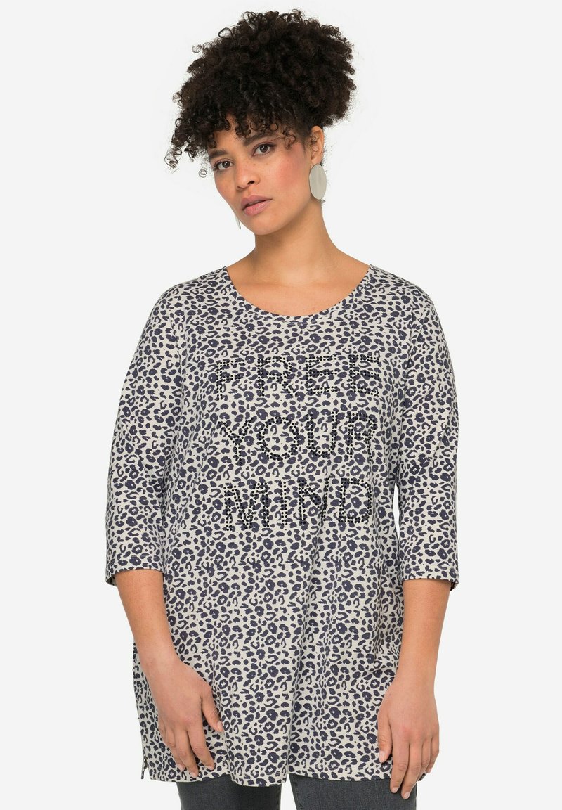 Leopardenmuster-Tunika in Beige und Marineblau, mit Dreiviertelärmel und rundem Halsausschnitt, verziert mit dem Text "FREE YOUR MIND" in Kristall-Applikationen.