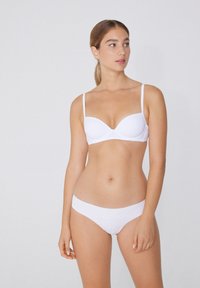 Biały stanik i pasujące majtki bikini wykonane z gładkiego materiału, z dekoltem w serek i cienkimi, regulowanymi ramiączkami.