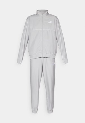 Hallhalli halliseks valmistatud kerge kangaga hall treeningkostüüm, millel on lukuga jakk, seisev krae ja elastsed mansetid, ning sobivad kitsenevad püksid.