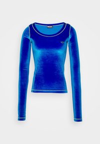 Blå sammet långärmad skjorta med rund halsringning, kontrasterande gula stygn och en liten logotyp på bröstet. Mjuk och slät textur.