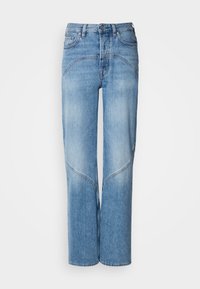 Ανοιχτό μπλε τζιν παντελόνι έχει άνετη εφαρμογή, φαρδιές γραμμές και καμπύλες ραφές. Ο ιστός έχει λεία υφή με ελαφριά φθορά.