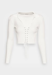 Top cropped de manga longa canelado branco, com um decote em V profundo, gola larga e detalhe frente com cordão ajustável e ilhós metálicos.