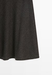 Wollrock mit Hahnentrittmuster in Dunkelgrau und Braun, mit ausgestellter Silhouette und glatter Textur, knielanger Schnitt.