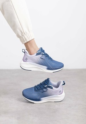 Zapatillas deportivas en azul y morado con parte superior texturizada, cordones prominentes y suelas blancas acolchadas. Incluyen un logo en el costado y una pestaña en el talón.
