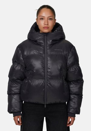 Giacca a vento nera con una finitura lucida e trapuntata; presenta un colletto alto e un ampio cappuccio; include zip sulle tasche e una chiusura frontale.