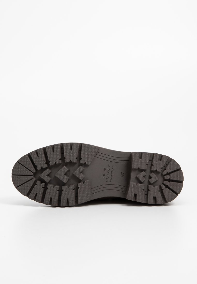 Schwarze Gummistiefelsohle mit strukturiertem Profilmuster und eckigen Rillen. Mit dem Markenlogo und der Größe (37) auf der Oberfläche gedruckt.