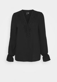 Blouse noire avec un décolleté en V dotée de détails en dentelle sur le devant. Manches longues et bouffantes avec des poignets élastiques. Texture de tissu lisse.