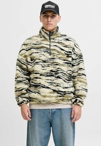 Fleece-Pullover mit hohem Kragen in Beige mit schwarzen und braunen Tigerstreifen; verfügt über einen Reißverschluss vorne und eine entspannte Passform.