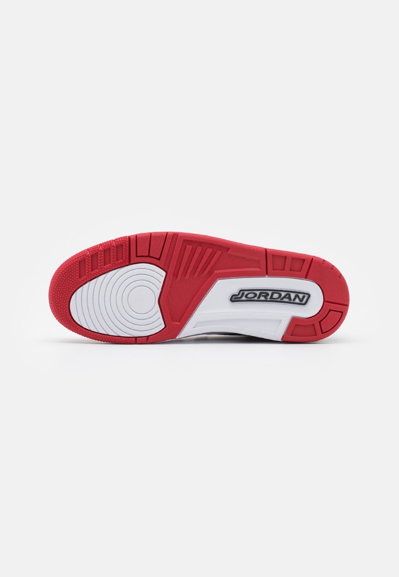 Suola di scarpa da ginnastica rossa e bianca con una superficie in gomma testurizzata, motivi circolari, sezioni rinforzate e la parola "JORDAN" in evidenza.