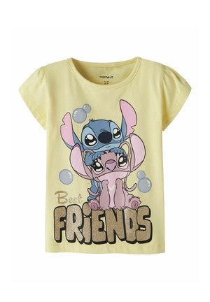 Żółta dziecięca koszulka z postaciami z kreskówki Stitch i Angel obejmującymi się nad błyszczącym napisem "Best FRIENDS" oraz unoszącymi się bąbelkami.