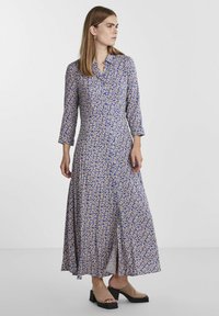 Maxi kleit kergest kangast, millel on krae, kolmeveerandsed varrukad, sinise ja beeži lilleline muster, pleeditud seelik ja külgsalused.