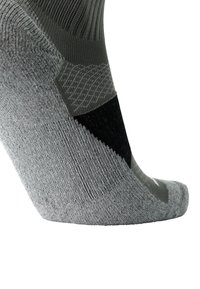 Media deportiva gris con textura acanalada, acento negro y áreas de talón y punta reforzadas para mayor durabilidad.