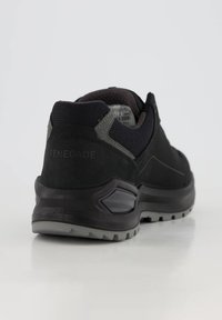 Czarne buty trekkingowe z teksturowaną cholewką, wzmocnionymi zielonymi akcentami i trwałą gumową podeszwą z bieżnikiem zapewniającym przyczepność.