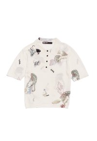 Polo in tessuto bianco sporco con colletto e maniche corte, decorato con motivi floreali e animali colorati. Chiusura con quattro bottoni.