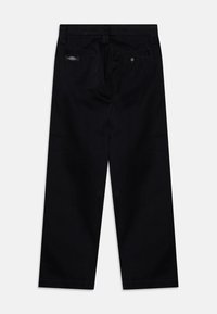 Black denim pants with a straight leg design, featuring two back pockets, a metal button closure, and minimal brand tag detail.