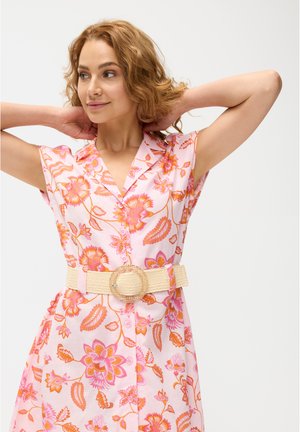 Florales Kleid in Rosa mit orangenen Mustern, mit kurzen Ärmeln und einer Knopfleiste vorne. Akzentuiert mit einem beigen gewebten Gürtel und einer runden Schnalle.
