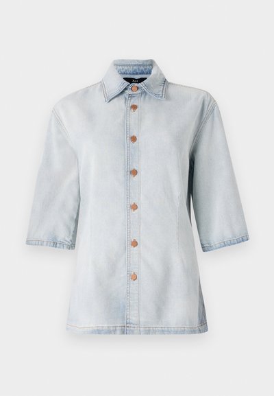 Camicia di jeans azzurro chiaro con maniche corte, chiusura a bottoni frontale e due tasche laterali. Presenta un colletto classico e bottoni in tono rame.