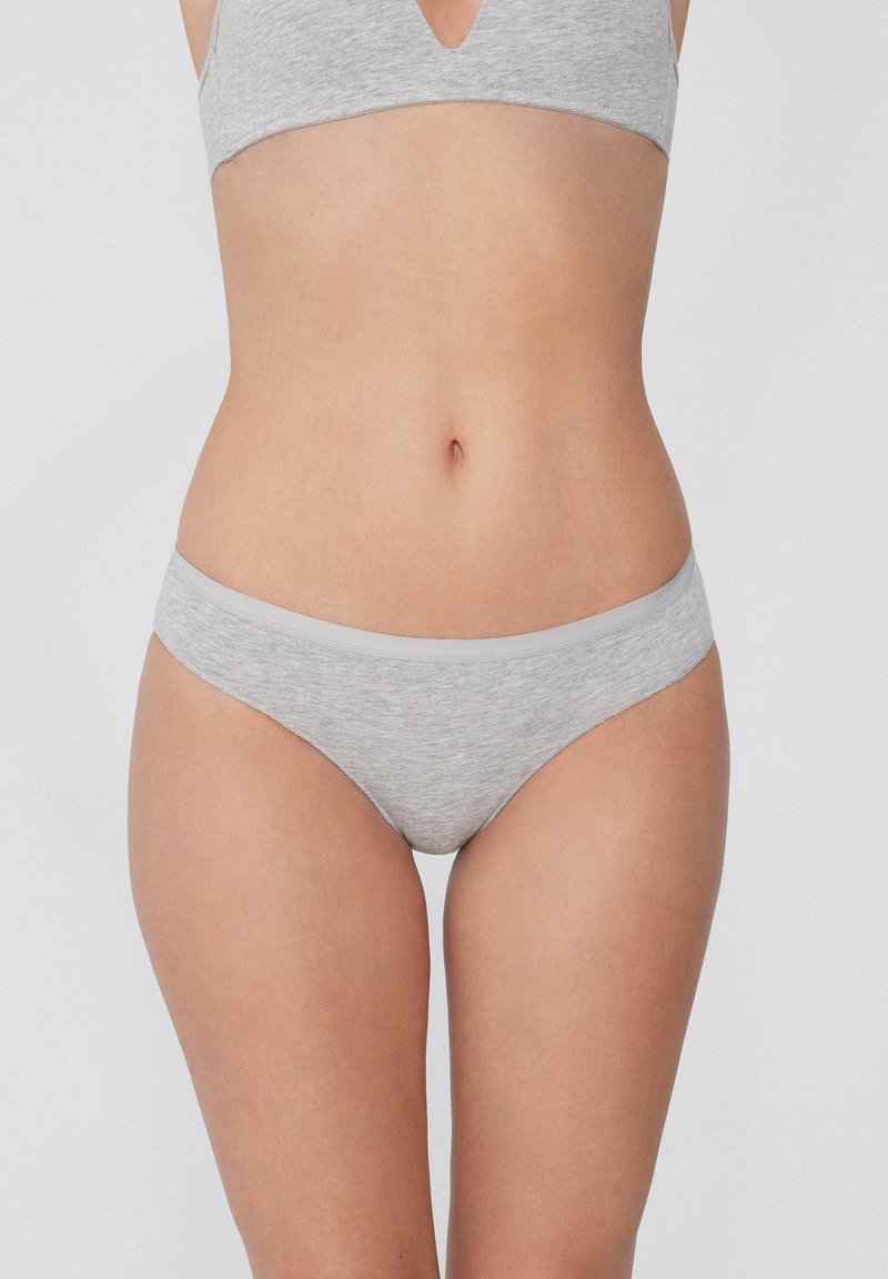 Šedé spodní prádlo vyrobené z měkké, pružné látky. Má hladký pás a klasický bikinový střih s jemnou texturou.