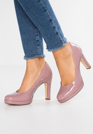 Roze patenten leren hoge hakken met een ronde neus, met een plateauzool en een slanke hak, gecombineerd met versleten blauwe denim cropped jeans.