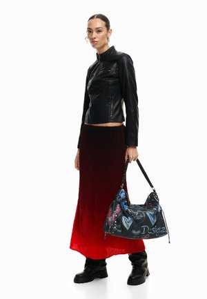 Femeie purtând o jachetă de piele neagră, fustă roșie ombre, cizme negre, ținând o geantă neagră cu inimioare colorate și text.