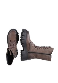 Brown leather combat boots with lace-up front, side zipper, and thick black rubber sole featuring pronounced treads. Textured finish.