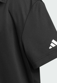 Schwarzes Polohemd aus Stoff mit kurzen Ärmeln, mit einem weißen Adidas-Logo auf dem linken Ärmel. Glatte Textur, klassisches Kragen-Design.