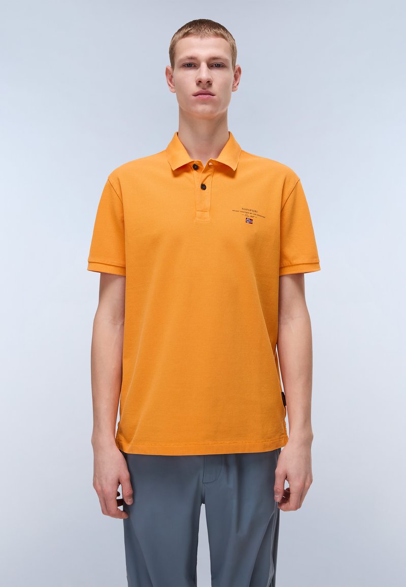 Camisa polo naranja hecha de algodón, con cuello y tres botones. Presenta un pequeño logo cerca del pecho y mangas cortas.