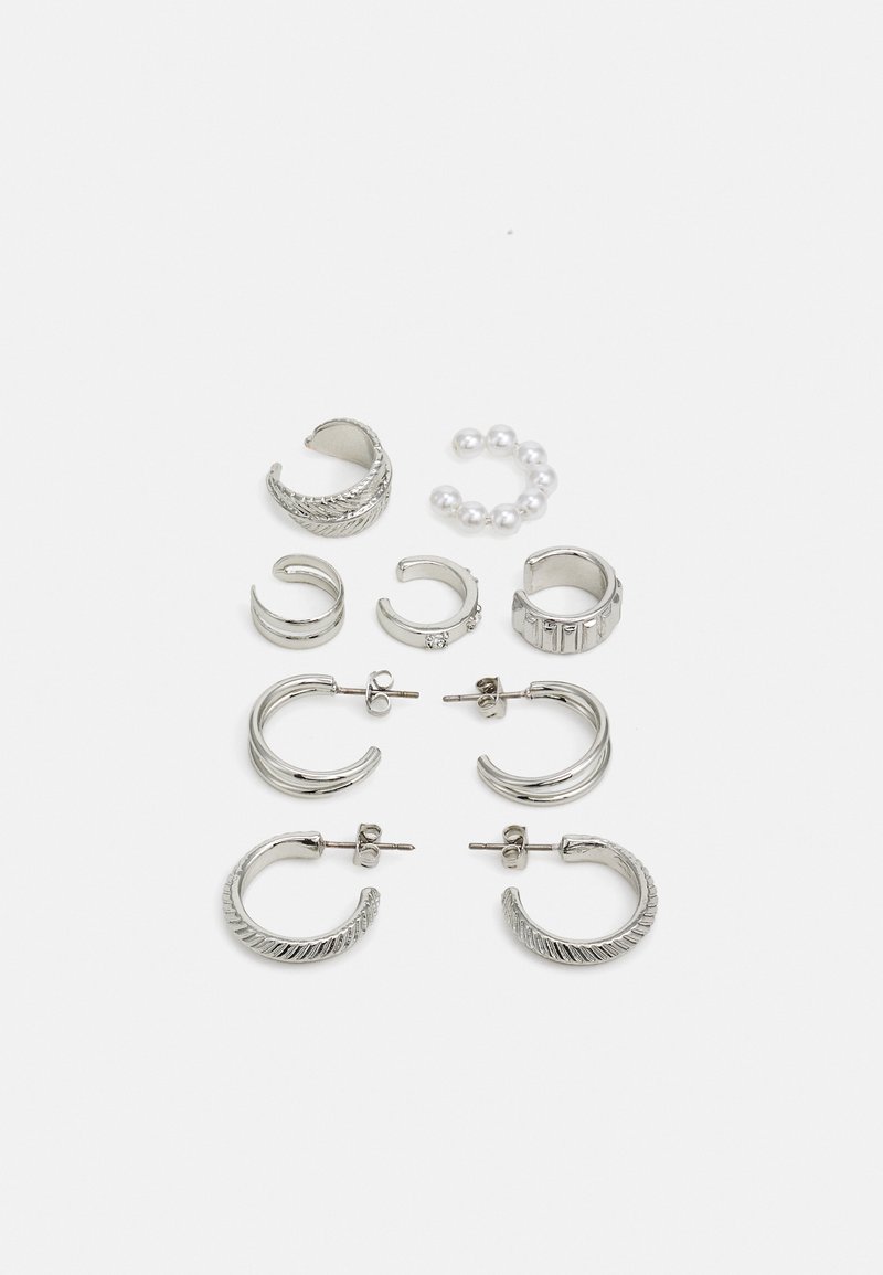 Conjunto de pendientes de plata que presenta varios diseños: aros texturizados, acentos de perlas y un patrón de líneas verticales. Incluye tipos de botón y aro.