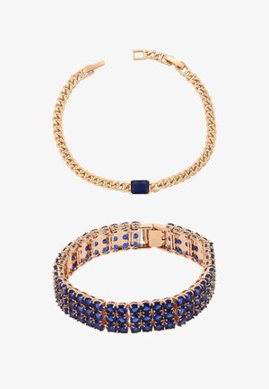 Två armband i guldfärg, ett med en enda rektangulär mörkblå ädelsten, det andra med flera små runda mörkblå stenar.