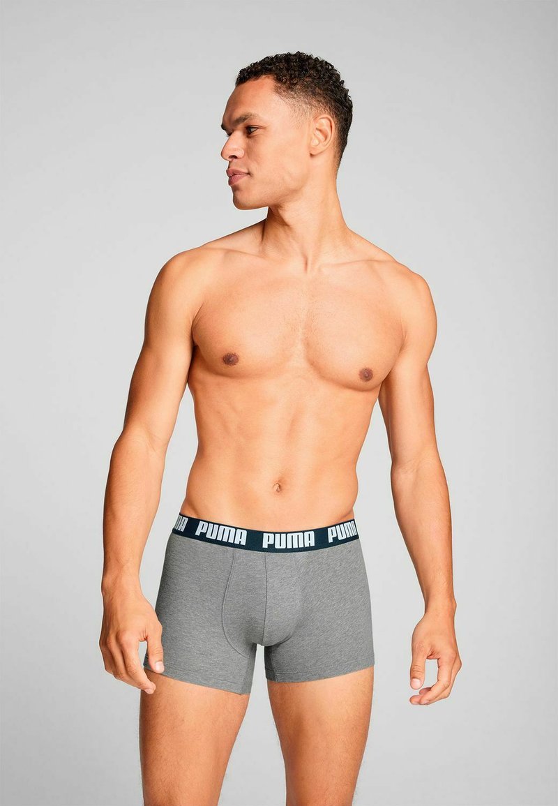 Gray boxer briefs with a black waistband featuring "PUMA" in white text. Smooth texture, fitted design, and mid-thigh length.
