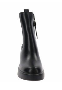 Botín negro de tobillo fabricado en cuero liso con puntera redondeada, cremallera lateral y suela de goma texturizada. Cuenta con una lengüeta en la parte posterior.